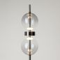 Preview: Close-up of 2 glass balls with a shiny metal ring between them on a black rod