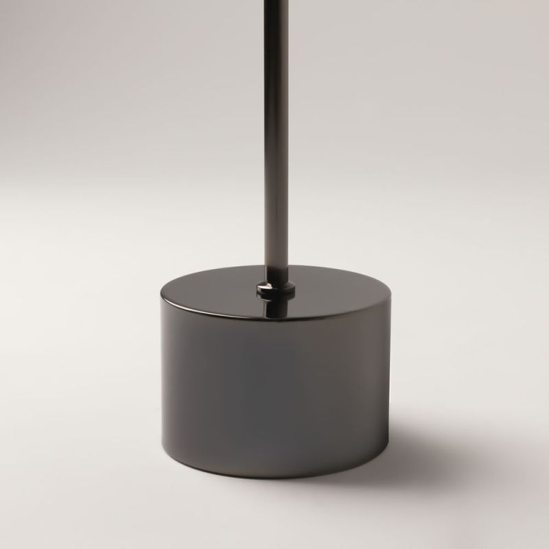 Round black base of the Double Moon floor lamp with slim rod rising upward