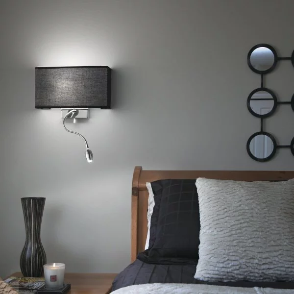 Schwarze Wandlampe mit LED Leselampe neben dem Bett eingeschaltet Schwarze Wandlampe mit LED Leselampe neben dem Bett eingeschaltet