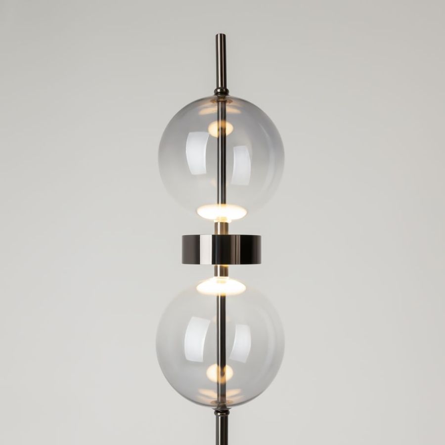 Close-up of 2 glass balls with a shiny metal ring between them on a black rod