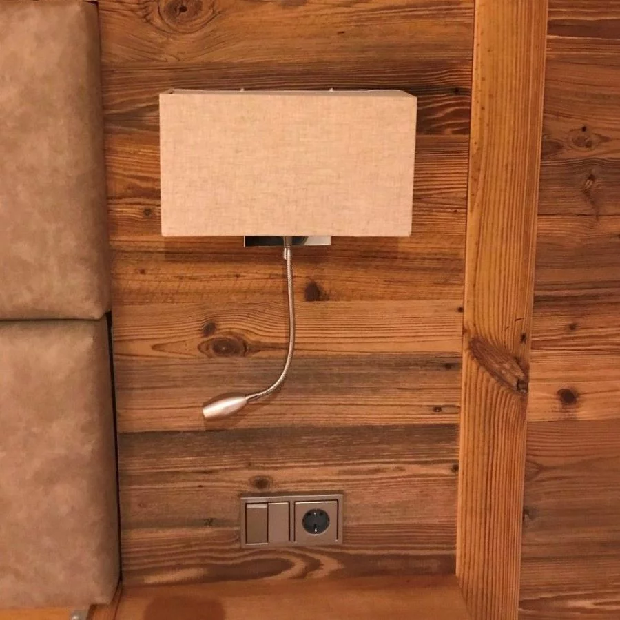 Braune Wandlampe mit LED Lesearm neben dem Bett Braune Wandlampe mit LED Lesearm neben dem Bett