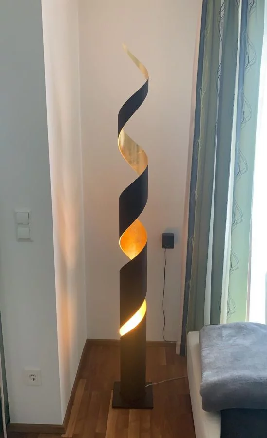 Floor lamp Truciolo in the corner, color dark brown/leaf gold